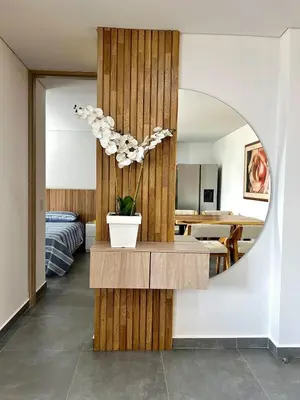 a room with a mirror and a table with a plant at Moderno Apartamento Sabaneta - Century Tower II in Sabaneta