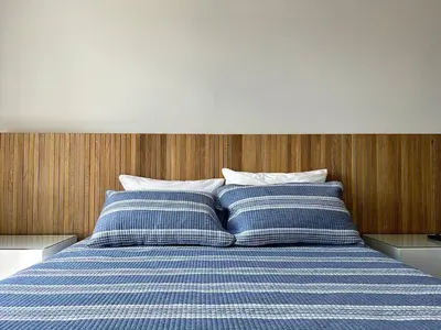 a bed with two blue and white striped pillows at Moderno Apartamento Sabaneta - Century Tower II in Sabaneta