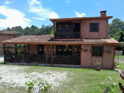 a brick house with a gate in a yard at Finca el Majagual in Guatapé