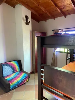 a living room with a chair and a bunk bed at Finca el Majagual in Guatapé
