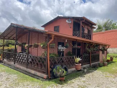 a house with a fence and plants in front of it at Finca el Majagual in Guatapé