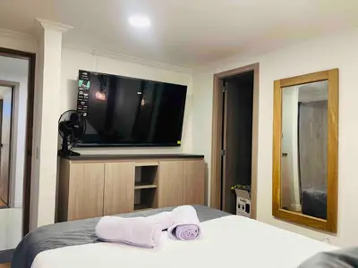 a bedroom with a bed and a flat screen tv at Casa Amsterdam with Jacuzzi in Poblado Medellín in Medellín