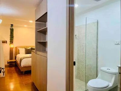 a bathroom with a toilet and a bedroom with a bed at Casa Amsterdam with Jacuzzi in Poblado Medellín in Medellín