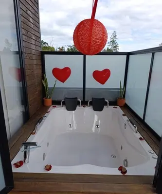 a bath tub in a room with hearts on the windows at Gampling el Cielo los pinos in Rionegro