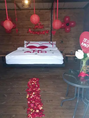 a bedroom with a bed and a bunch of flowers at Gampling el Cielo los pinos in Rionegro