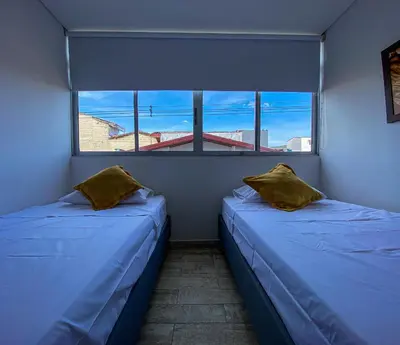 two beds in a room with two windows at Hermoso Apartamento Frente al Embalse 2 Habs View in Guatapé