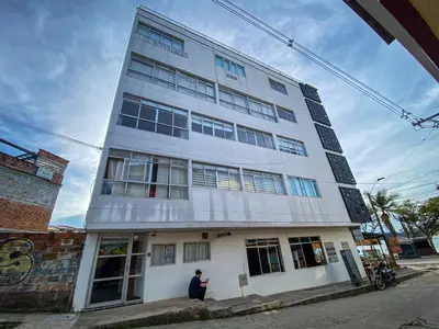 a man standing in front of a white building at Hermoso Apartamento Frente al Embalse 2 Habs View in Guatapé