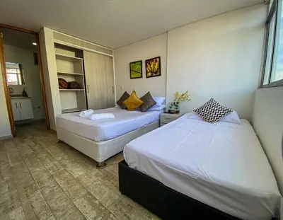 a hotel room with two beds and a window at Hermoso Apartamento Frente al Embalse 2 Habs View in Guatapé