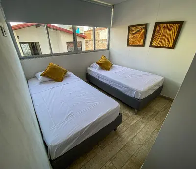 two beds in a small room with two windows at Hermoso Apartamento Frente al Embalse 2 Habs View in Guatapé