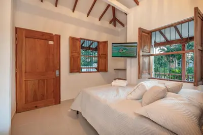 a bedroom with a bed and a large window at Pool, Views, Sauna, Bar, Fire Pit and 24 HR Security in Medellín