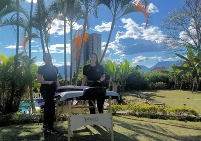 two people sitting at a table in a park at Pool, Views, Sauna, Bar, Fire Pit and 24 HR Security in Medellín