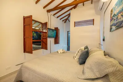 a bedroom with a bed with a tv on the wall at Pool, Views, Sauna, Bar, Fire Pit and 24 HR Security in Medellín