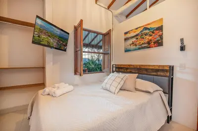 a bedroom with a bed and a tv on the wall at Pool, Views, Sauna, Bar, Fire Pit and 24 HR Security in Medellín
