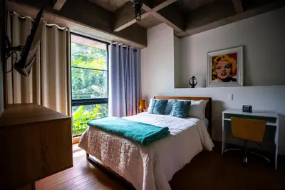 a bedroom with a bed and a desk and a window at Home away from home - By Adri in Envigado