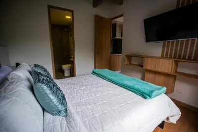 a bedroom with a white bed with blue pillows on it at Home away from home - By Adri in Envigado