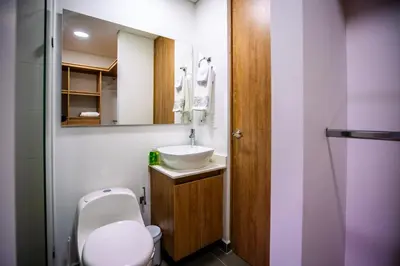a bathroom with a toilet and a sink and a mirror at Home away from home - By Adri in Envigado