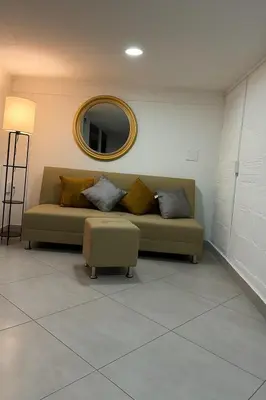 a living room with a couch and a mirror at Cozy 2BR in Prime El Poblado in Medellín