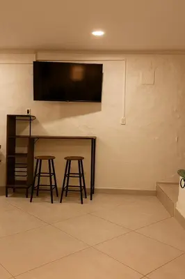 a bar with stools and a flat screen tv on a wall at Cozy 2BR in Prime El Poblado in Medellín