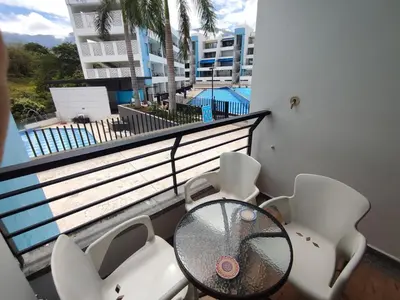 a balcony with a glass table and white chairs at San Jeronimo - Apartamento - Hospedaje in San Jerónimo