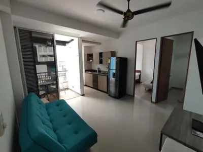 a living room with a blue couch and a kitchen at San Jeronimo - Apartamento - Hospedaje in San Jerónimo