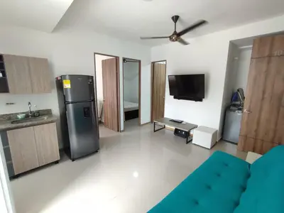 a living room with a blue couch and a kitchen at San Jeronimo - Apartamento - Hospedaje in San Jerónimo