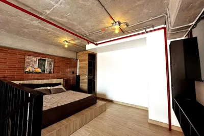 a bedroom with a bed and a brick wall at Central Medellin Modern Loft - Balcony and Transit in Medellín