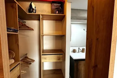 a walk in closet with wooden shelves and a sink at Central Medellin Modern Loft - Balcony and Transit in Medellín