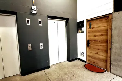 a hallway with two white doors and a red rug at Central Medellin Modern Loft - Balcony and Transit in Medellín