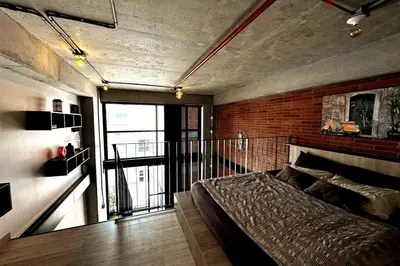 a bedroom with a bed and a brick wall at Central Medellin Modern Loft - Balcony and Transit in Medellín