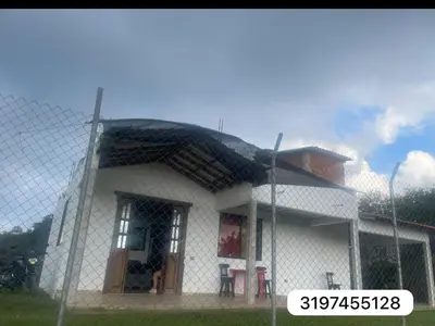 a white house behind a chain link fence at CASA FINCA San Rque Antioquia in San Roque