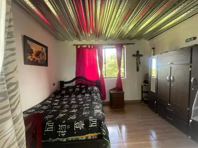 a bedroom with a bed with red curtains and a window at CASA FINCA San Rque Antioquia in San Roque