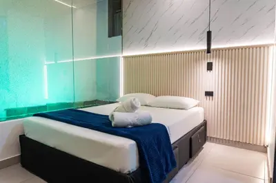 a bedroom with a large bed with a blue blanket at hotel civitas medellin in Medellín