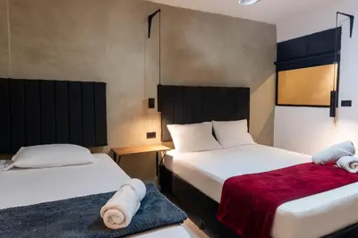 two beds in a hotel room with towels at hotel civitas medellin in Medellín