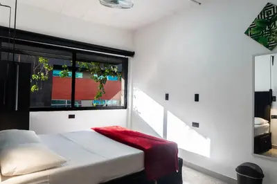 a bedroom with a bed and a large window at hotel civitas medellin in Medellín
