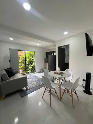 a living room with a table and chairs and a couch at Apartamento en La America 2 habitaciones in Medellín