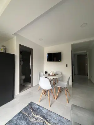 a living room with a table and white chairs at Apartamento en La America 2 habitaciones in Medellín