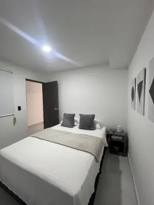 a white bedroom with a large bed with two pillows at Apartamento en La America 2 habitaciones in Medellín