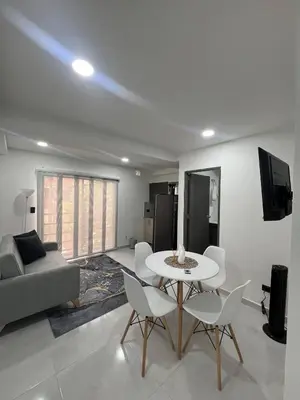 a living room with a table and chairs and a couch at Apartamento en La America 2 habitaciones in Medellín