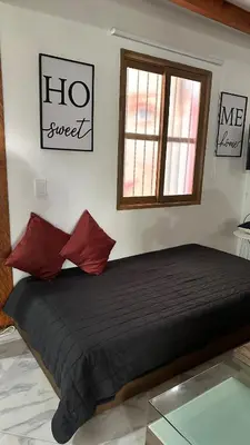a bedroom with a bed with red pillows and a window at Casa Madeira in Rionegro