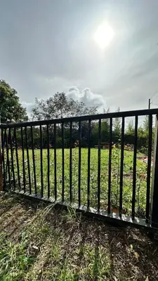 a black fence in front of a field at Casa Madeira in Rionegro