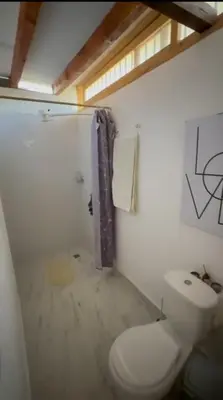 a white bathroom with a toilet and a sink at Casa Madeira in Rionegro