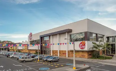 a parking lot with cars parked in front of a store at Casa Madeira in Rionegro