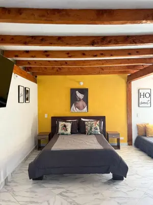 a bedroom with a bed and a yellow wall at Casa Madeira in Rionegro