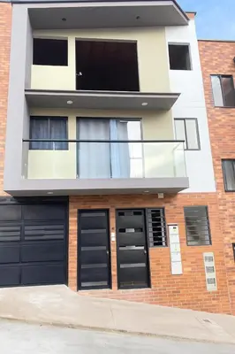 a house with black garage doors on a brick building at Casa moderna en el centro Carmen V WI-FI in Carmen de Viboral