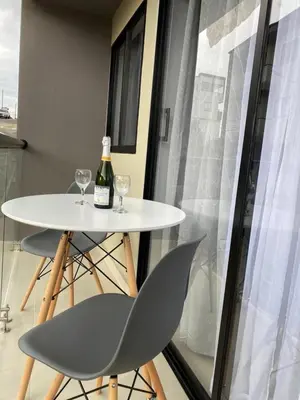 a white table with two glasses and a bottle of wine at Casa moderna en el centro Carmen V WI-FI in Carmen de Viboral