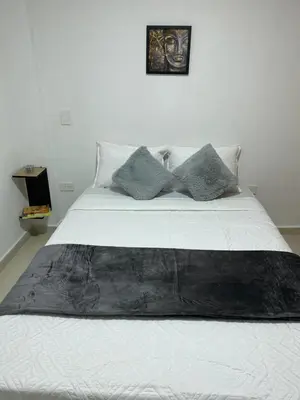 a bed with a black blanket on top of it at Casa moderna en el centro Carmen V WI-FI in Carmen de Viboral