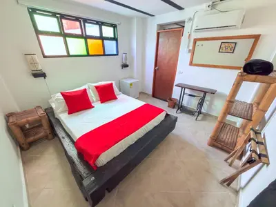 a bedroom with a bed with red pillows and a ladder at Solvae EcoHotel in San Jerónimo