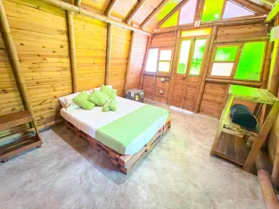 a bedroom with a bed in a wooden cabin at Solvae EcoHotel in San Jerónimo