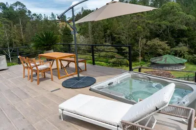 a hot tub on a deck with a table and chairs at Sahara Lodge Nature, Design Arabian Horses in El Retiro
