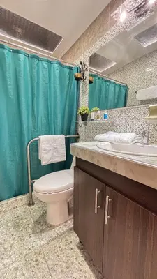 a bathroom with a toilet and a blue shower curtain at Casa Boutique Familia Hurtado in Manizales